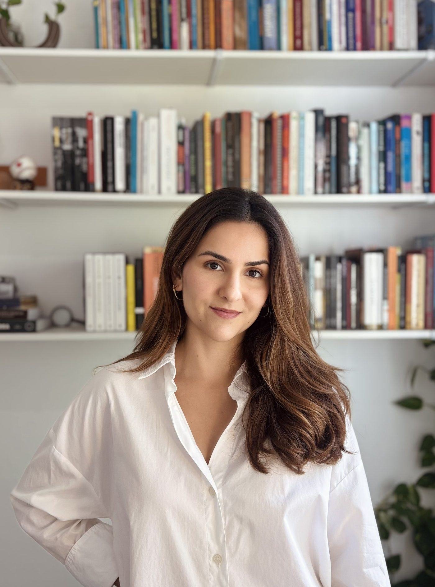 Júlia de Freitas Martins, psicanalista, em frente a uma estante de livros